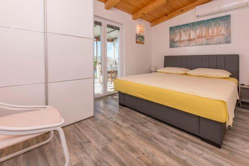 a bedroom with a bed and a chair at House Osti in Rogoznica