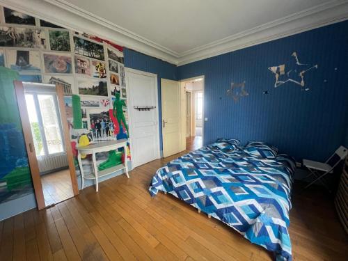 a bedroom with a bed and a blue wall at Paradeux - Chambre dans grande Maison Gite sur Argenteuil, Parking dans cour securisée, pour ouvriers ou groupes de travailleurs in Argenteuil