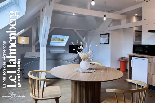 Una mesa de comedor y sillas en una sala de estar. en Le Hahnenberg - la Maison des Vignerons, en Orschwiller