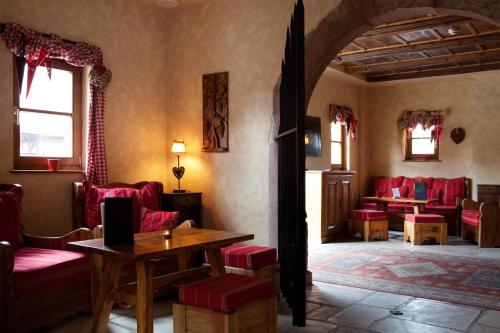 a living room with red chairs and a table at Le Domaine de Rouffach in Rouffach