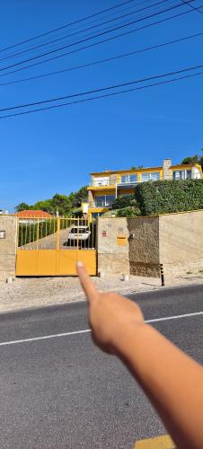 a persons hand pointing at a street with a road at Mega Ocean Magoito - Sintra in Sintra