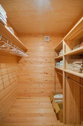 a wooden walk in closet with wooden walls and shelves at Matsushima hill bungalow in Matsushima