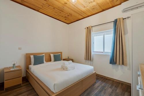 a bedroom with a large bed and a window at Casa Bauínia in Setúbal