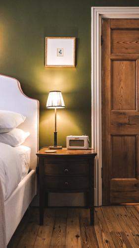 a bedroom with a bed and a table with a lamp on it at Fothergill House - Entire Luxury Townhouse - City Centre in Nottingham