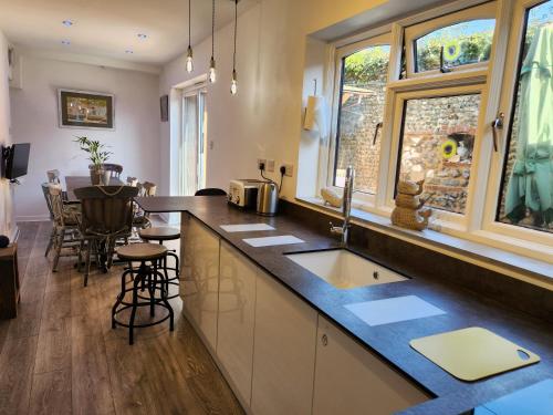 a kitchen with a sink and a counter top at AnchorageWells Entire Cottage in Wells next the Sea