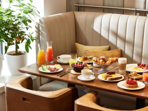 uma mesa com alimentos e bebidas para o café da manhã em Sofitel Paris Arc De Triomphe em Paris