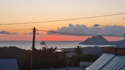 a view of the ocean at sunset from a house at Mango Studio in Sainte-Luce