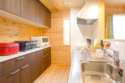 una cucina con lavello e microonde di Matsushima hill bungalow a Matsushima