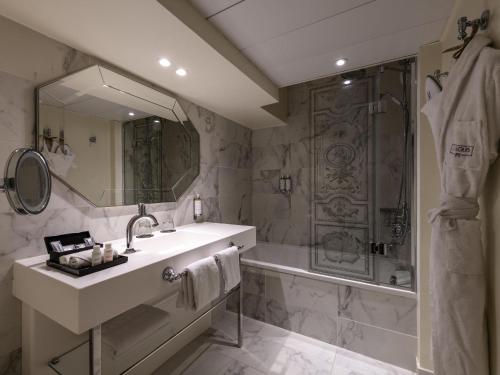 W łazience znajduje się umywalka, prysznic i wanna. w obiekcie Le Louis Hotel Versailles Château - MGallery Collection w Wersalu