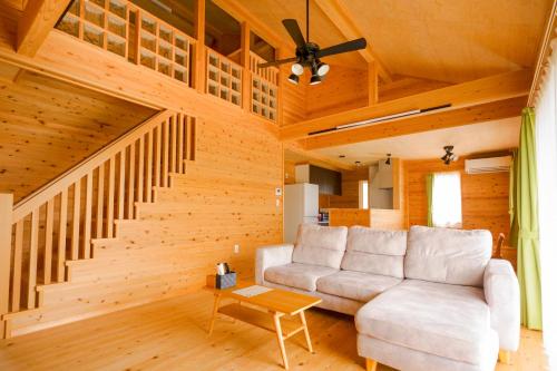a living room with a couch and a staircase at Matsushima hill bungalow in Matsushima