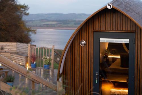 a wooden building with a door with a view of the water at Seaview Cabin Sleeps 2 -Hot Tub - Parking in Newburgh