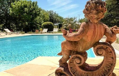 a statue sitting next to a swimming pool at Maison Avec Piscine Et Jacuzzi in Allex