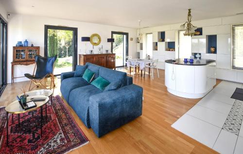 a living room with a blue couch and a kitchen at Maison Avec Piscine Et Jacuzzi in Allex