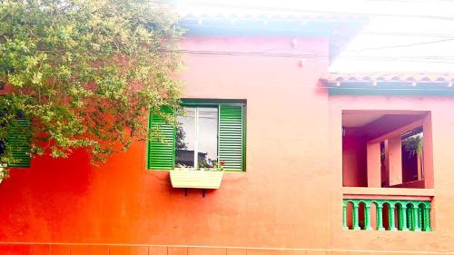 a colorful building with a window with a flower box at Casa Flores na Janela in Socorro