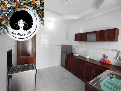 a kitchen with a sink and a picture of a woman at Kwa Mzungu Villa in Nungwi