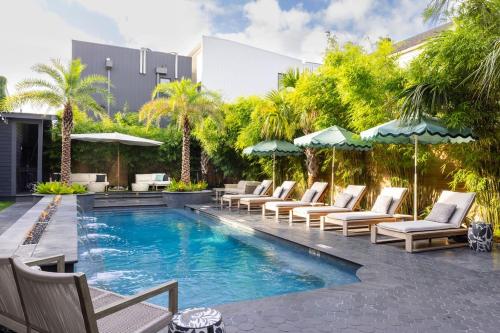 a resort pool with lounge chairs and umbrellas at Blackbird Hotel in New Orleans