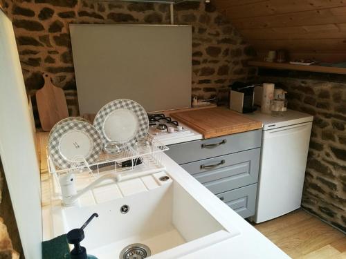 Una pequeña cocina con fregadero y estufa. en Suite sauna jacuzzi hammam, en Trans