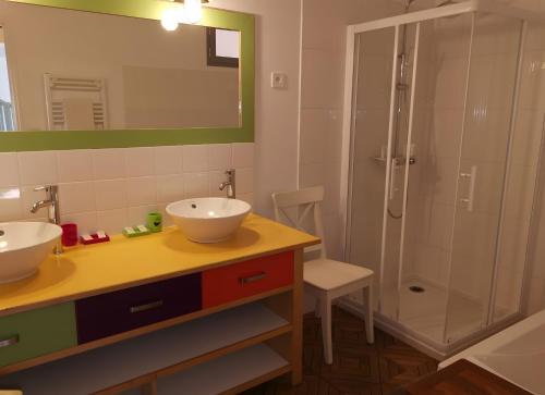 Un baño con dos lavabos y una ducha. en Gîte bien-être avec spa, en Trans