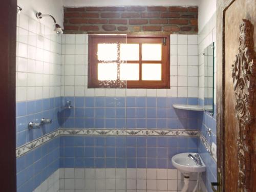 a bathroom with blue and white tiles and a sink at Chalé Carnaval Olinda 14000 RS in Olinda
