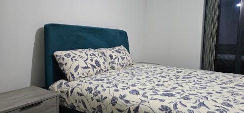 a bed with a blue head board and a pillow at Cozy Broad Street Apartment Central and Comfortable in Birmingham