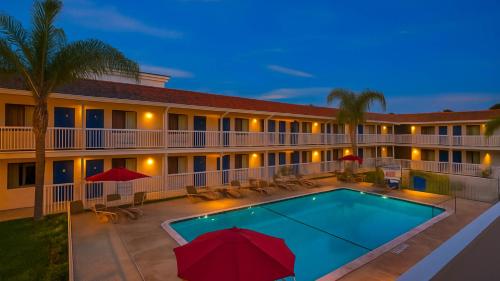 a pool in front of a hotel at night at Motel 6-Carlsbad, CA Beach in Carlsbad