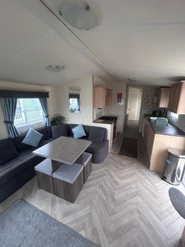 ein Wohnzimmer mit Sofa und Tisch in der Unterkunft Spacious 10 birth Caravan Golden palm resort chapel st leonards Skegness in Chapel Saint Leonards
