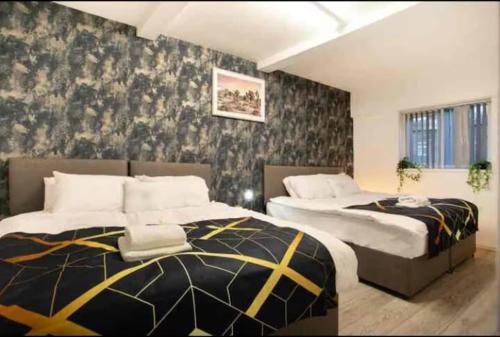 ein Schlafzimmer mit zwei Betten und einem Wandbild in der Unterkunft Base is a lovely place to unwind after a long day in Wincobank