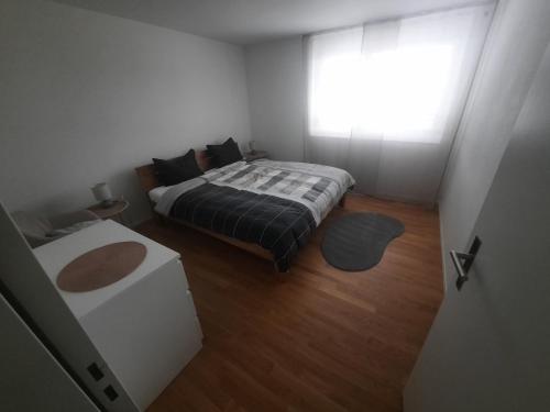 a small bedroom with a bed and a window at Zimmer 1, Haus der Begegnung in Goldingen
