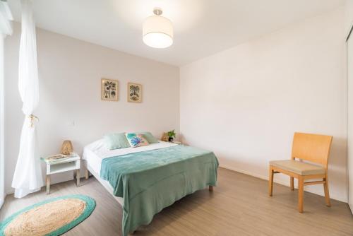 een slaapkamer met een bed en een stoel bij Résidence de Perros-Guirec in Perros-Guirec