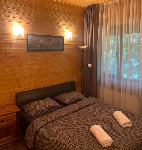a bedroom with a bed with two towels on it at Tauriņkrasti in Bērzciems