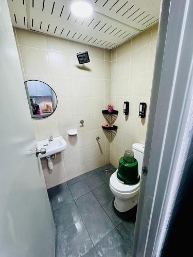 a bathroom with a toilet and a sink and a mirror at AzHomes AG in Kampong Jelatang