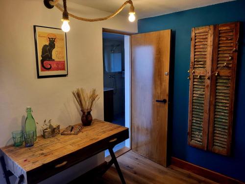 a room with a wooden table and a blue wall at This Old House in Ponta do Pargo