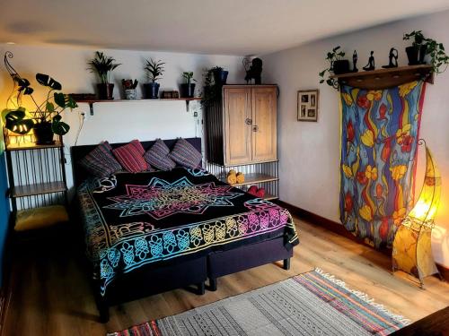 Un dormitorio con una cama con una manta colorida. en This Old House, en Lombada Velha