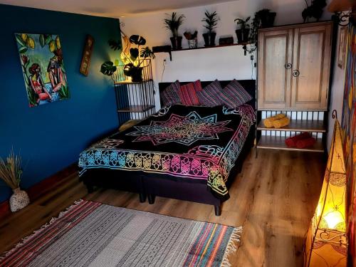 Un dormitorio con una cama con una manta colorida. en This Old House, en Lombada Velha