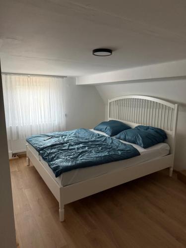 a bedroom with a bed with blue pillows on it at Fewo Donna in Altensteig