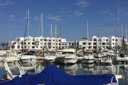 a bunch of boats docked in a marina with a building at Charmant Studio Port El Kantaoui in Hammam Sousse