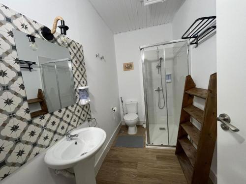 a bathroom with a sink and a shower and a toilet at Gar House in Caleta de Interián