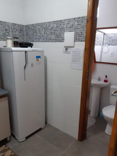 a small kitchen with a refrigerator and a toilet at Recanto do Sol Pousada in Capão da Canoa