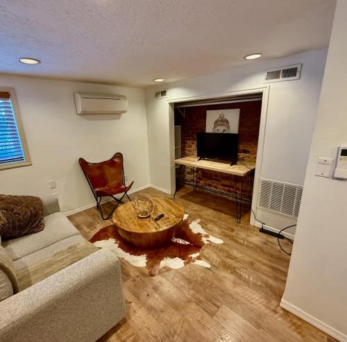 a living room with a couch and a table at Charming Marmalade Flat in Downtown Salt Lake City in Salt Lake City