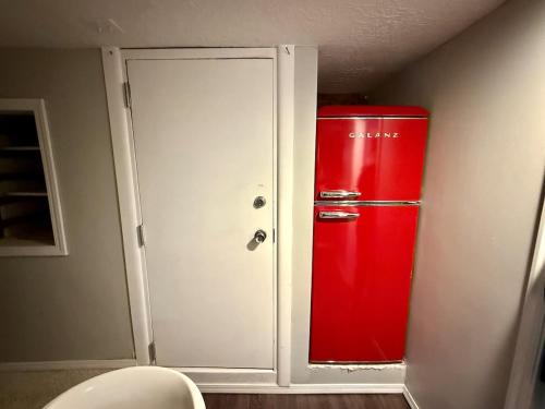 a red refrigerator sitting next to a white door at Charming Marmalade Flat in Downtown Salt Lake City in Salt Lake City