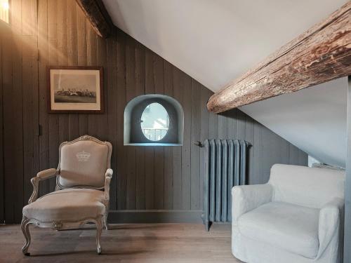 a living room with a chair and a window at La Divine Comédie-Suites Deluxe in Avignon