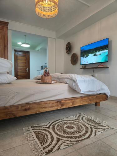 a bedroom with a large bed with a flat screen tv at Studio Amorisca Peaceful 2-Person Stay in Flic-en-Flac