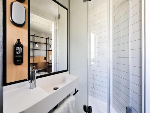 un baño con lavabo y espejo en Ibis Paris Tour Eiffel Cambronne 15ème, en París