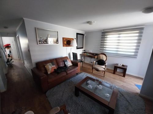 a living room with a couch and a coffee table at Comfortable House, 10 Min from Viña, 4 people in Quilpué