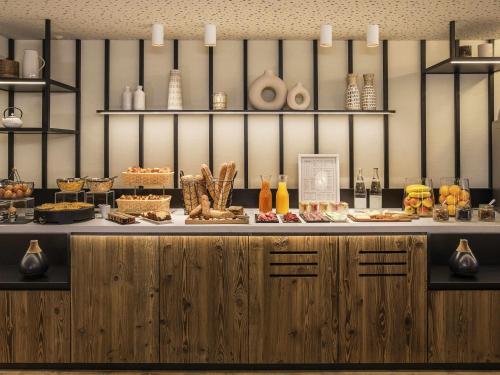 a counter with a buffet of food on it at Mercure Chambéry Centre in Chambéry