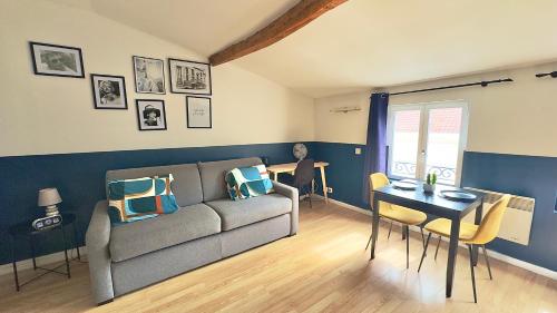 a living room with a couch and a table at Le Photographe Cosy Douai centre in Douai