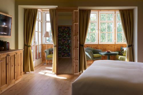 a bedroom with a bed and a large window at Berghoferin Fine Hotel & Hideaway in Redagno