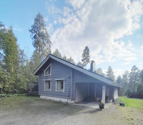 a small blue house in a yard at Villa Lähde Päijätsalon järvimaisemassa in Sysmä
