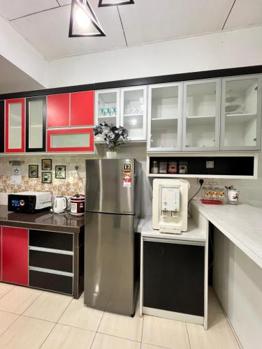 a kitchen with red and white cabinets and a refrigerator at Gemilang Guesthouse in Sungai Petani
