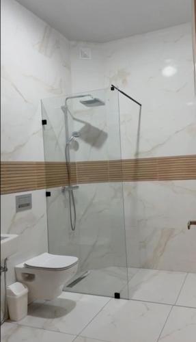 a bathroom with a glass shower and a toilet at front of beach apartement taghazout in Taghazout